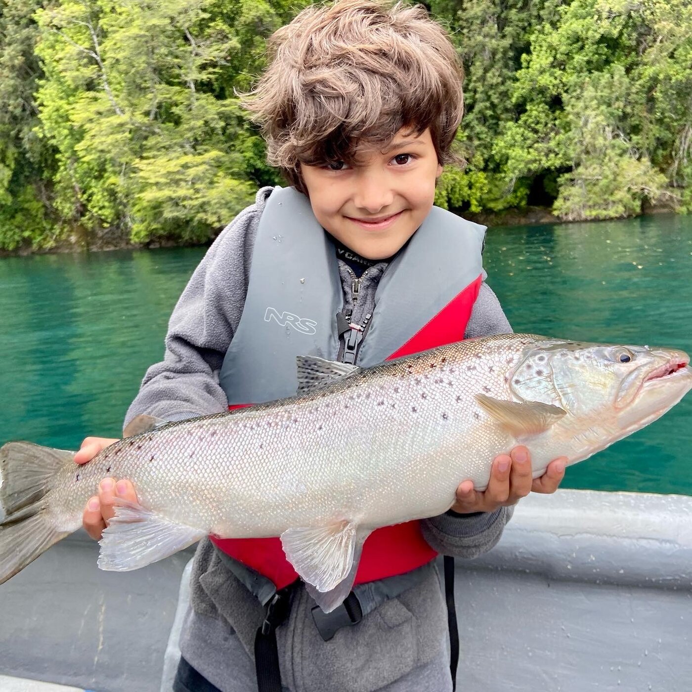 Niño con trucha en el lago Yelcho