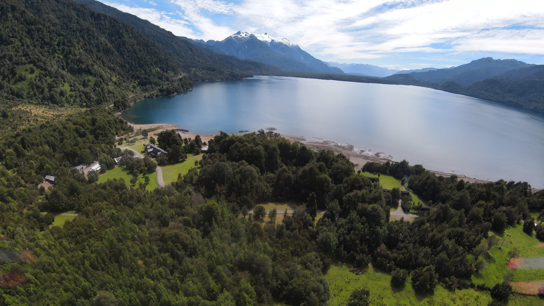 Vista aérea del Hotel Yelcho a orillas del lago, rodeado de bosque nativo y montañas